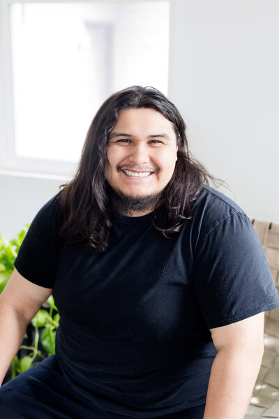 Emilio smiling in front of a window