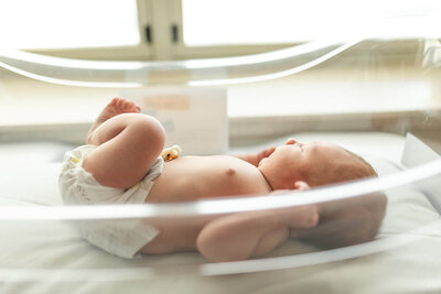 Newborn baby boy lays in his hospital bassinet during his Fresh 48 session in New Ulm, Minnesota.