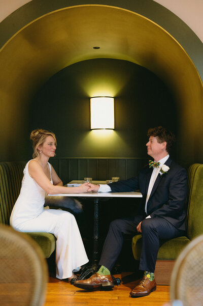 Virginia wedding photographers wedding picture with man and woman sitting together in an alcove with dark green accents and a table