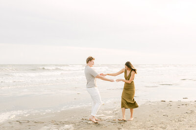 engaged couple splashing on galveston beach