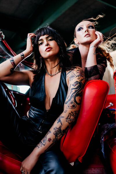 two women with tattoos posing in a car