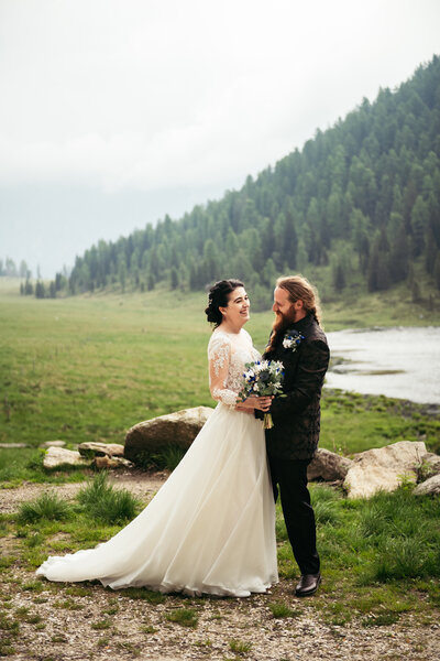 The bride, framed by majestic mountains in Bressanone, exudes natural beauty and serenity against the picturesque alpine landscape on her special day