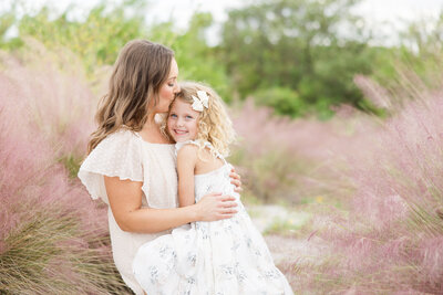 Mom and daughter kissing on forehead