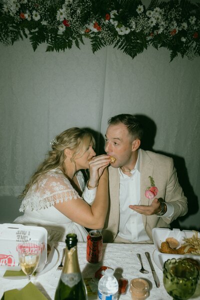 couple sharing food with interlocked arms