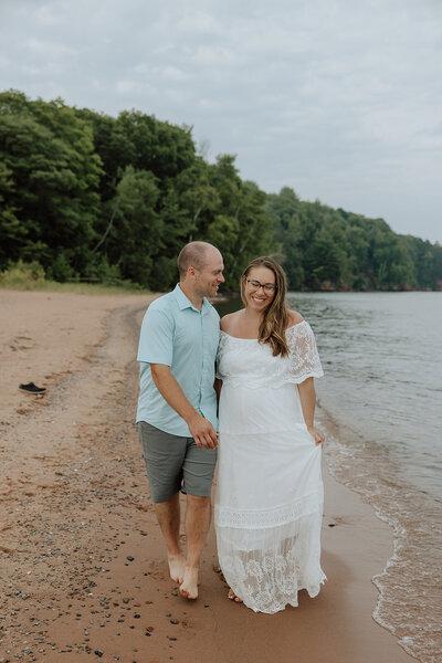 bride and groom walking along a beach on the apostle islands