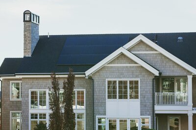 Contemporary multi-story house featuring sleek rooftop solar panels installed for residential energy efficiency