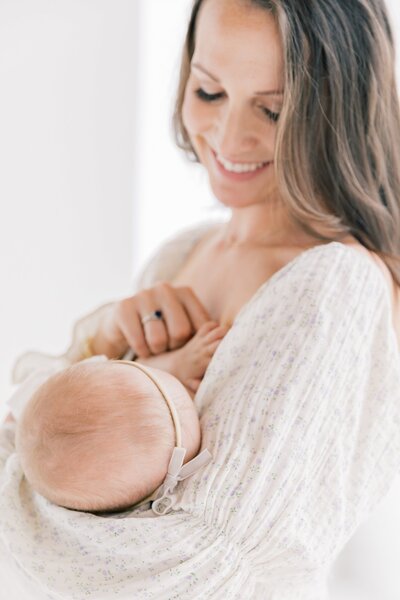 A mother cradling her baby girl by charlotte portrait photographer