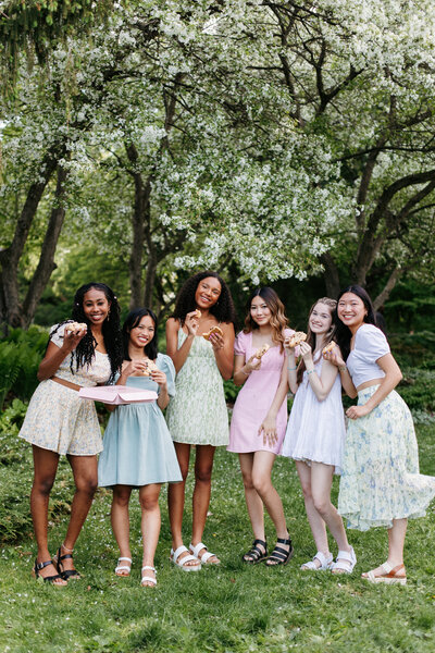 Group of senior girls wearing floral dresses and holding cookies