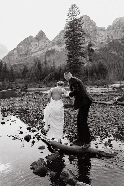 photo of bride and groom walking next to lake with mountains in the background taken by Jackson Hole photography