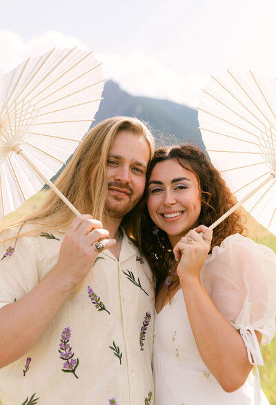 Couple smiling with parasols during a Halfway House wedding in Boulder, Colorado