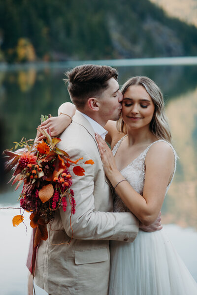 couple kisses in forest