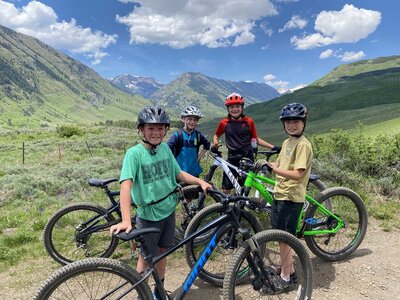 MKP kids pictured with their mountain bikes on a mountain trail