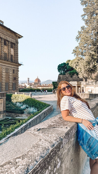 Woman leaning on wall at Pitti Palace in Florence Italy