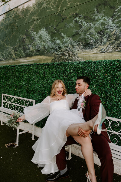 A person sitting on a bench with their partner in their lap