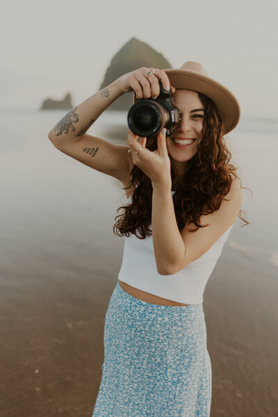 Artistic shot of a woman sitting in a field under the full moon, holding a camera, capturing the beauty of solitude and the connection to nature