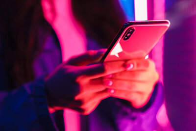 Close up photo of girl typing on photo, ambient red and purple light