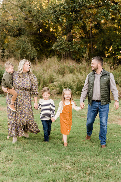Family walking while holding hands during their fall photos with