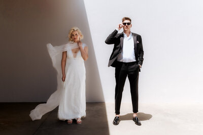 Braut und Bräutigam schauen cool in die Kamera im zeitlosen editorial  look.