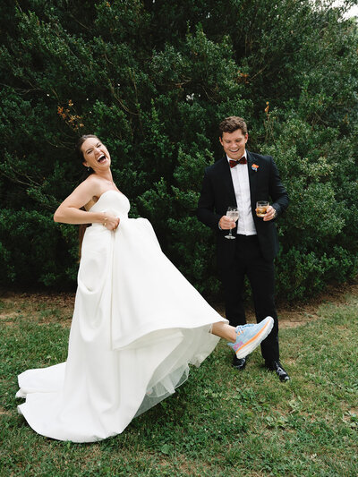Bride showing her groom her hoka sneakers after their ceremony.