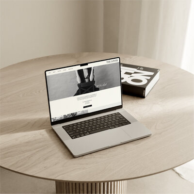 Laptop sitting on a wood table displaying the lover website