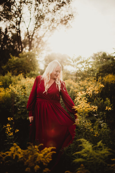 Erin Scott, a Milwaukee  wedding photographer holding the end of her dress and smiling