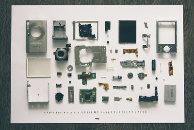 Deconstructed camera parts set up neatly at 90 degree angles which is called knolling