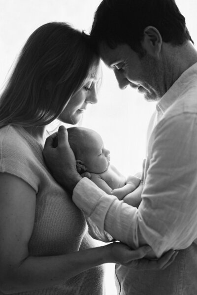 Baby being held by mum and dad in Billingshurst photoshoot