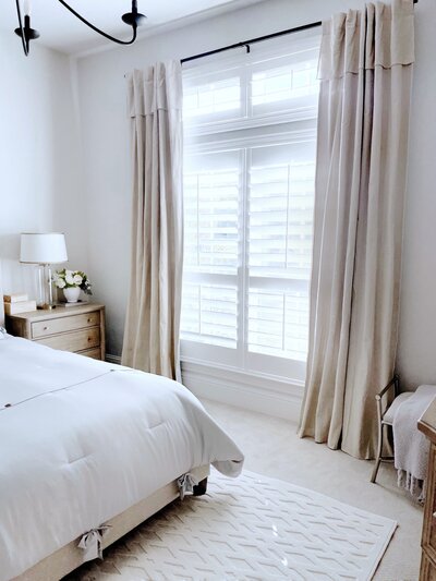 Bedroom space featuring MTH curtains hung up above open window