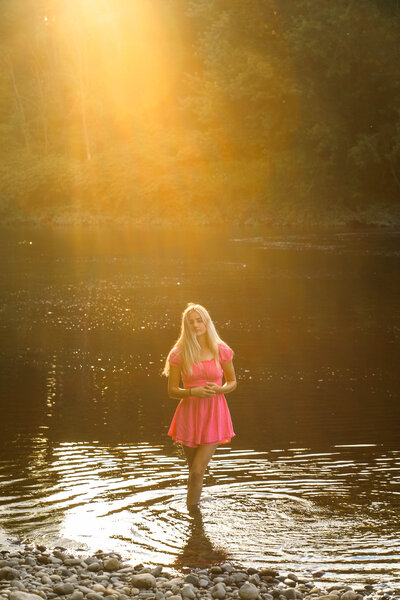 Girl in pink dress standing in water | Senior Session