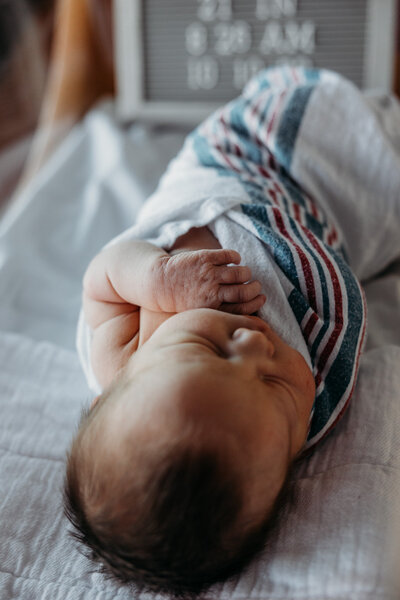 details of a brand new baby snuggled in the crib at the hospital for a fresh 48 photoshoot in charlevoix michigan