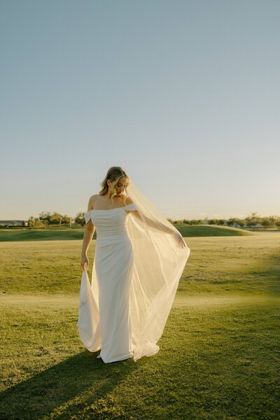 bride poses for portraits after wedding