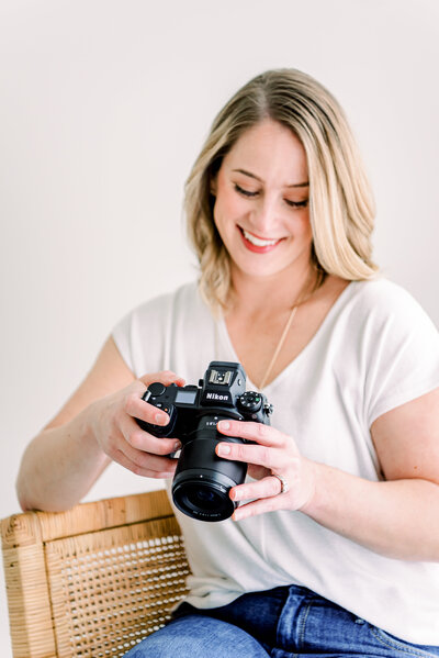 Photographer Valerie Worth holds camera in Raleigh photography studio