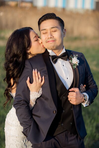 Bride kissing groom on the cheek