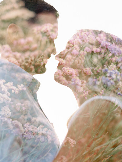 Man and woman with their faces close together double exposed with a photo of flowers
