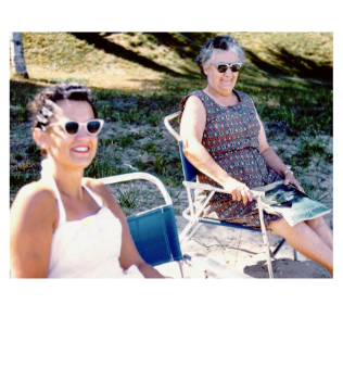 Women sitting at beach with vintage sunglasses
