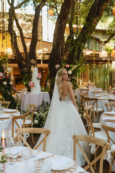 a bride standing in the middle of all her reception tables