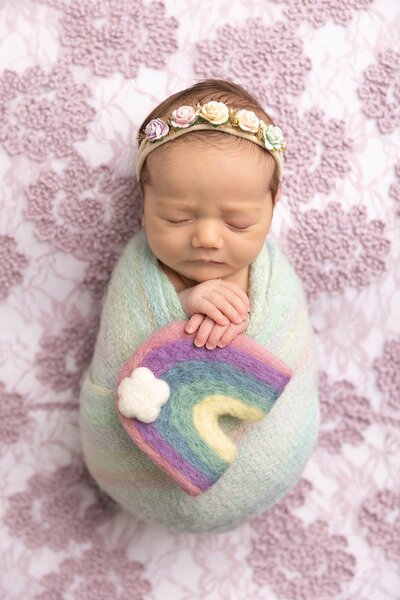 newborn wrapped holding a rainbow for Newborn Photography Bucks County PA