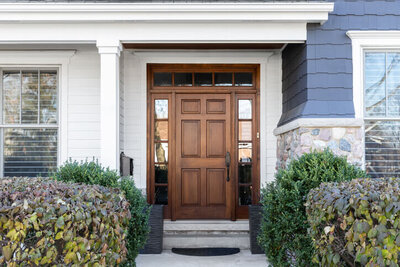 Front door installation with wood finish by Black Bear Roofing & Exteriors.