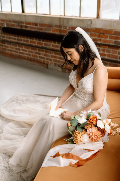 Bride holding up a bouquet of flowers during a beach elopement in Michigan.