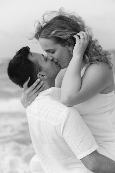 woman and man kissing on beach