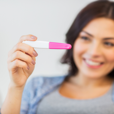 Woman smiling at pregnancy test - Ashley Hutt Certified Hypnotherapist, hypnotherapy, hypnosis, hypnotist, rapid transformational therapy, RTT, RTT therapist, rapid transformational therapist, fertility, infertility, hypnobirthing, moms, motherhood, emotional maturity, Louisville Kentucky, louisville, kentucky, southern indiana, kentuckiana, jeffersonville indiana, new albany indiana, clarksville indiana, madison indiana.