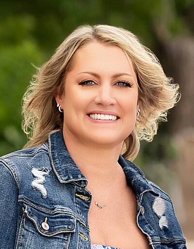 Laury, studio assistant, is pictured smiling in an outdoor portrait.