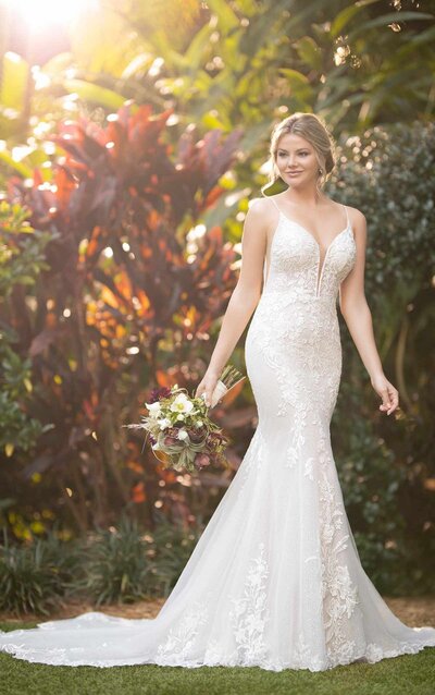 SPARKLING FIT-AND-FLARE WEDDING DRESS WITH SIDE CUTOUTS This gown was made to help show off your natural shine on your big day. A sultry silhouette smooths over the curves gracefully with a plunging V-neckline and whisper-thin straps, bedecked in gorgeous beading for a dazzling effect. The deep side cutouts mirror the neckline and open V-back, while a combination of glitter tulle and honeycomb tulle creates a mix of textural shine throughout the lacy silhouette. Organically placed laces along the hem create a uniquely scalloped train for the grand finale.