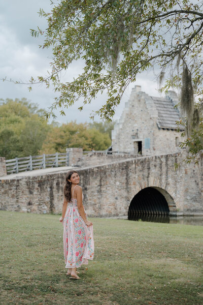 Young woman twirling under flying confetti on a white Southern-style porch during a joyful celebration session in Alabama — EC Photography