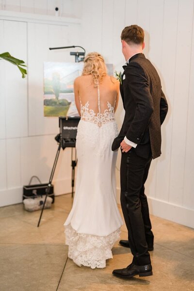 bride and groom admiring a painting