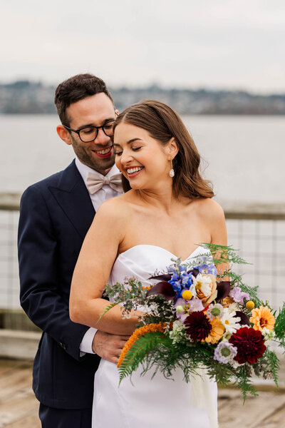 bride and groom, sitting on sculpture outside of the realm venue in Tacoma, during sunset