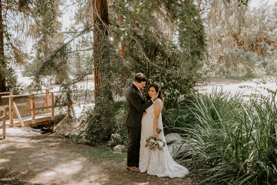 bride and groom embracing in forest