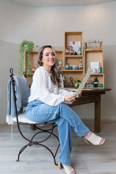 Merlyn Asencio smiling warmly while holding her Blueprint, reflecting her confidence and commitment to guiding clients through their healing journey with trauma therapy in Miami, Florida