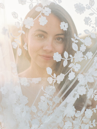 Close up of bride's face shot through her floral veil