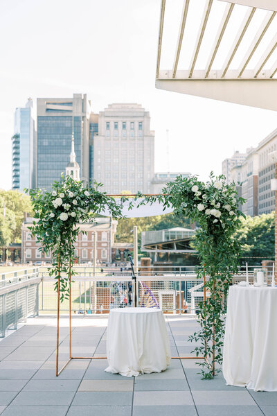 Elegant indoor wedding ceremony with luxurious floral installations by Leigh Florist, featuring roses, greenery, and candlelit accents for a timeless look